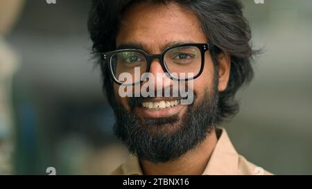 Nahaufnahme Porträt glücklicher indischer bärtiger Geschäftsmann der 30er Jahre in Brille männlich posiert für Kamera. Gutaussehender arabischer multiethnischer Mann im Brillengeschäft Stockfoto