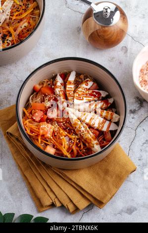 Asiatische Reisnudeln mit Gemüse, Sauce und Huhn in einer Schüssel Stockfoto