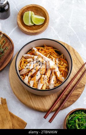 Traditionelle asiatische Nudeln mit Gemüse und Huhn in einer Schüssel Stockfoto