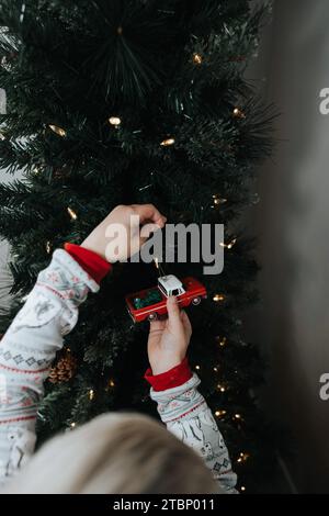 Junge hängt Truck Ornament an Baum Stockfoto