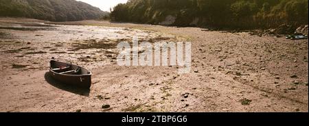 Ein Kanu am Strand in St-Anthony-in-Meneage, Cornwall. Ein 35-mm-Filmpanorama auf Fujicolour-Schaft mit einem Hasselblad Xpan. Stockfoto