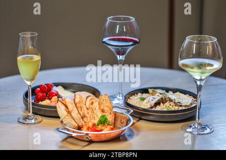 Eleganter Esstisch mit Wein und Gourmetgerichten. Gourmetküche und gehobene Küche. Stockfoto