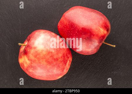 Zwei rote Bio-Äpfel auf Schieferstein, Makro, Draufsicht. Stockfoto