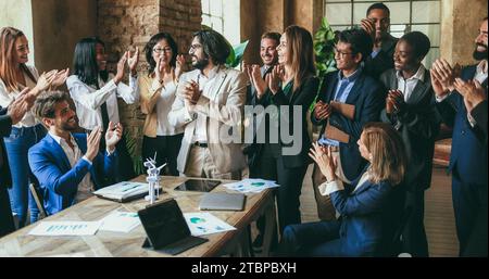 Generationenübergreifende Kollegen klatschen für ein erfolgreiches Projekt im Bereich grüne Energie in modernen Büros – Teamwork begrüßt sich gegenseitig für env Stockfoto