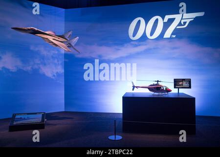 Prag, Tschechische Republik, 8. Dezember 2023. Pressetag bei der Ausstellung „Bond in Motion“ auf dem Messegelände in Prag, Tschechische Republik. Die Ausstellung umfasst sechs Jahrzehnte James Bond Filmgeschichte und umfasst über 75 Fahrzeuge. Die Ausstellung ist bis zum 31. März 2024 geöffnet. Im Bild: Bell 206 Jetranger Miniatur aus „for Your Eyes Only“ und MIG 29 Miniatur aus „Goldeneye“ © Piotr Zajac/Alamy Live News Stockfoto