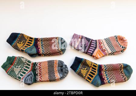 Vier Paar farbenfrohe Wintersocken mit verschiedenen Mustern, isoliert auf weißem Hintergrund. Stockfoto