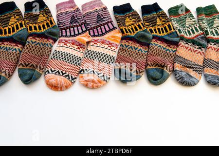 Eine Reihe farbenfroher Wintersocken mit verschiedenen Mustern, isoliert auf weißem Hintergrund. Stockfoto