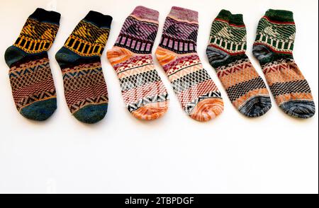 Eine Reihe farbenfroher Wintersocken mit verschiedenen Mustern, isoliert auf weißem Hintergrund. Stockfoto