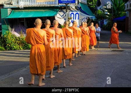 Lampang, Thailand - 2. Dezember 2023: Thai Theravada buddhistische Mönche gehen für Morgenalmen in Nakhon Lampang, Thailand. Stockfoto