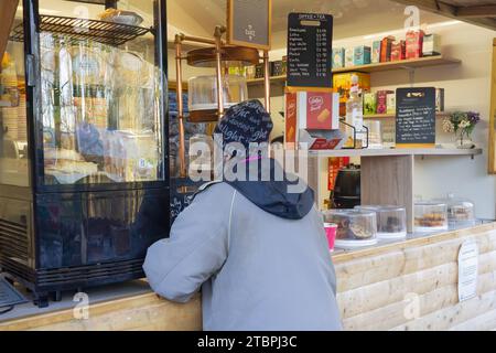 06.12.2023 Entwistle, Bolton, Lancashire, Frau in Blau, die im Café im Turton Tower Essen bestellt Stockfoto