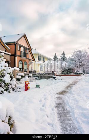 Gereinigter Weg entlang der Reihe von Wohnhäusern im Winter Stockfoto