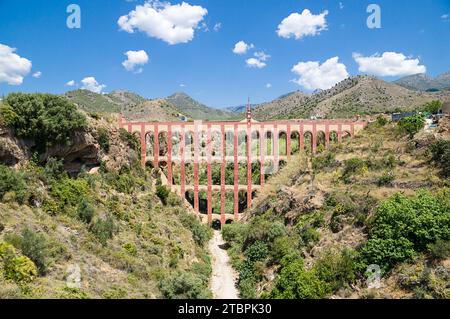 Eine malerische Brücke zwischen üppigen grünen Bäumen und sanften Bergen schafft einen atemberaubenden ausblick in diese malerische Landschaft Stockfoto