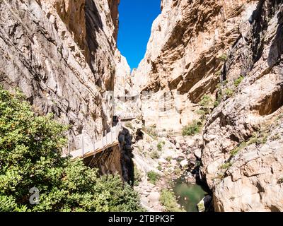 Ein schmaler Canyon mit schroffen Felswänden auf beiden Seiten, einer Brücke, die die Lücke in der Mitte überspannt und einem kleinen Bach, der durch den Boden fließt Stockfoto