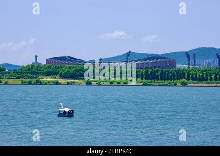 in der dynamischen Umgebung des Ttukseom Hangang Park, Seoul, befindet sich ein Entenboot auf dem Fluss han vor dem imposanten Jamsil Stadium und schafft so einen beeindruckenden Eindruck Stockfoto