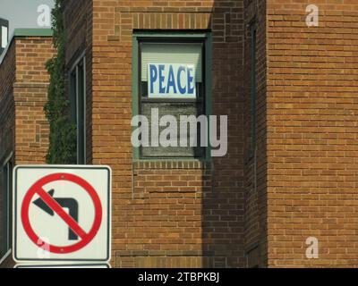 Auf diesem Bild sind Schilder an der Seite von Gebäuden abgebildet, die eine Rechtskurve mit einem Friedenssymbol verbieten Stockfoto