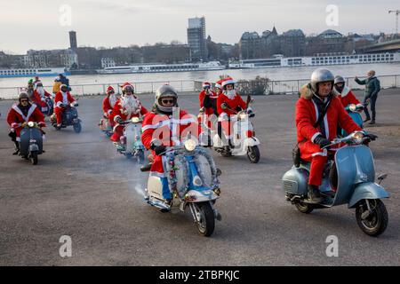 Mitglieder des Vespa-Rollervereins RheinSchalter Köln, als Santas gekleidet, treffen sich auf der Deutzer Werft vor einer Fahrt durch die Stadt Köln. Die Stockfoto