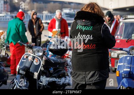 Mitglieder des Vespa-Rollervereins RheinSchalter Köln, als Santas gekleidet, treffen sich auf der Deutzer Werft vor einer Fahrt durch die Stadt Köln. Die Stockfoto