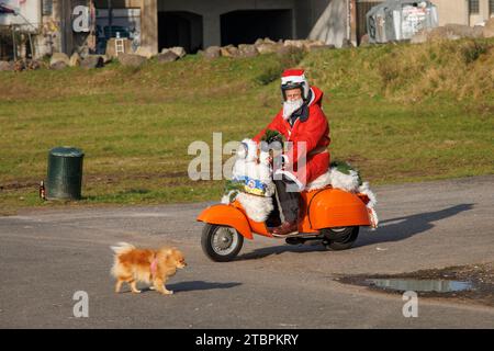 Mitglieder des Vespa-Rollervereins RheinSchalter Köln, als Santas gekleidet, treffen sich auf der Deutzer Werft vor einer Fahrt durch die Stadt Köln. Die Stockfoto