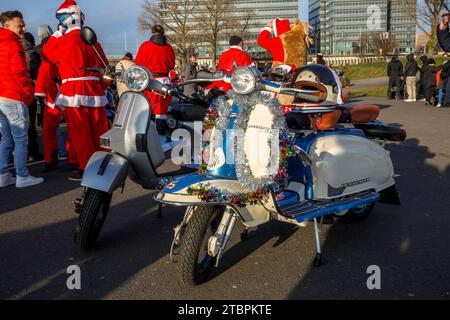 Weihnachtlich geschmückter Lambretta-Roller, Mitglieder des Vespa-Rollervereins RheinSchalter Köln, verkleidet als Santas, treffen sich auf der Deutzer Werft vor einer Fahrt Stockfoto