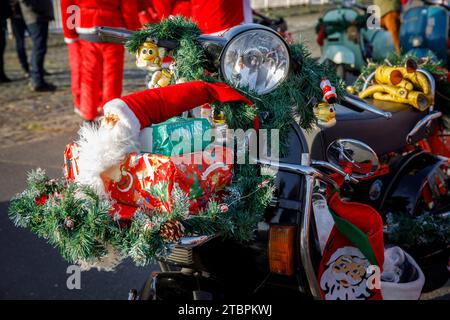 Weihnachtlich geschmückter Vespa-Roller, Mitglieder des Vespa-Rollervereins RheinSchalter Köln, verkleidet als Santas, treffen sich auf der Deutzer Werft vor einer Fahrt durch die Deutzer Werft Stockfoto