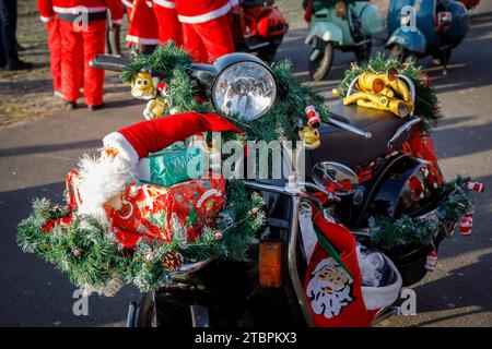 Weihnachtlich geschmückter Vespa-Roller, Mitglieder des Vespa-Rollervereins RheinSchalter Köln, verkleidet als Santas, treffen sich auf der Deutzer Werft vor einer Fahrt durch die Deutzer Werft Stockfoto