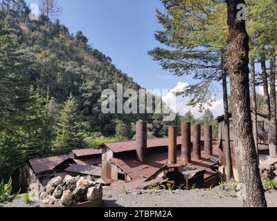 Dies ist ein Vintage-Haus mit einem Metalldach und rostenden Rohren in einer ländlichen Umgebung Stockfoto