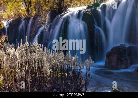 Dieses Bild zeigt eine atemberaubende natürliche Landschaft mit einem kaskadierenden Wasserfall, der an der Seite eines Berges verläuft Stockfoto