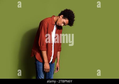 Foto-Porträt des gutaussehenden jungen Mannes, der müde unglücklich gekleidet ist, stilvolles braunes Outfit isoliert auf khakifarbenem Hintergrund Stockfoto