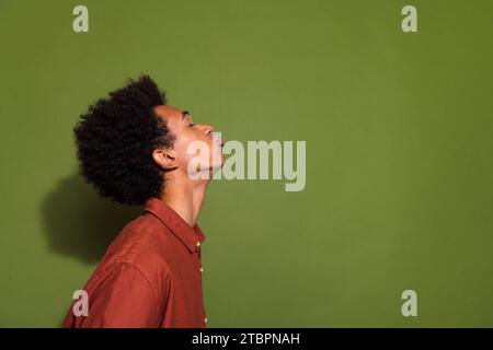 Foto-Porträt des attraktiven jungen Mannes Profil küssen leeren Raum gekleidete stilvolle braune Kleidung isoliert auf khakifarbenem Hintergrund Stockfoto
