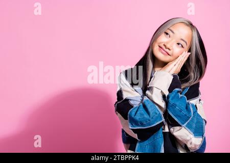 Foto von positivem nettem Mädchen gefaltete Arme Palmen unter Wangenausblick leerer Raum isoliert auf rosafarbenem Hintergrund Stockfoto