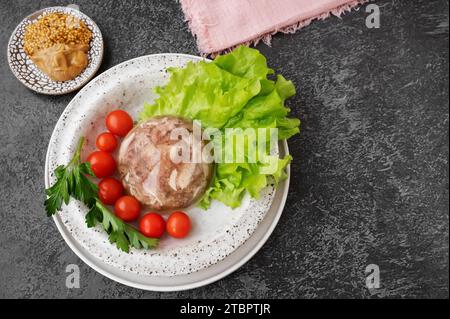 Hausgemachtes Gelée-Fleisch mit Senf und Meerrettich auf dem Tisch. Aspik. Hausgemachtes Gelee mit Senf, Tomaten und Knoblauch auf dem Tisch. Kholodets, trad Stockfoto