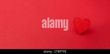 Rotes Holzherz auf rotem Hintergrund. Liebe, Valentinstag Karte, Banner Stockfoto