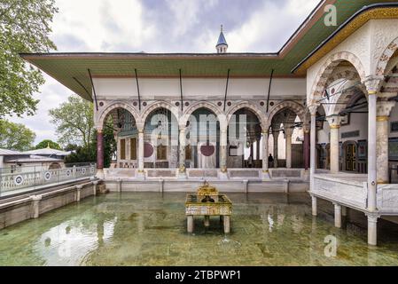 Bagdad Kiosk hinter einem dekorativen Wasserbrunnen, ein osmanischer Pavillon im vierten Innenhof des Topkapi-Palastes, Istanbul, Türkei. Dekoriert mit komplexen Blumenmosaiken und Marmorsäulen Stockfoto