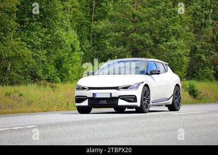 Weißes Kia EV6 vollelektrisches Auto bei Geschwindigkeit auf der Autobahn, grüner Waldhintergrund. Raasepori, Finnland. Juli 2023. Stockfoto