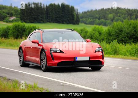 Wunderschönes rotes Porsche Taycan Sport Turismo Jahr 2022 Elektroauto auf der Landstraße an einem sonnigen Sommertag. Salo, Finnland. Juli 2023. Stockfoto