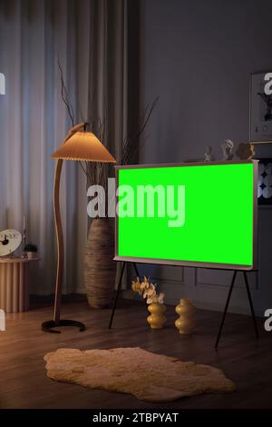 Die Menschen schauen und genießen neben dem Fernseher, Monitor mit grünem Bildschirm Stockfoto