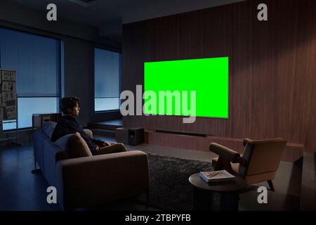 Die Menschen schauen und genießen neben dem Fernseher, Monitor mit grünem Bildschirm Stockfoto