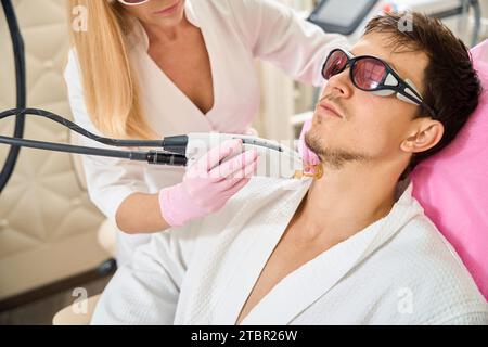 Mann, Klient des Schönheitssalons, der sich einer Laser-Haarentfernung unterzieht Stockfoto