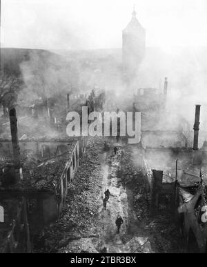 Infanteristen des 255. Infanterieregiments ziehen eine Straße in Waldenburg hinunter, um die Hunnen nach einem kürzlichen Überfall der 63. Division zu jagen. April 1945. Stockfoto