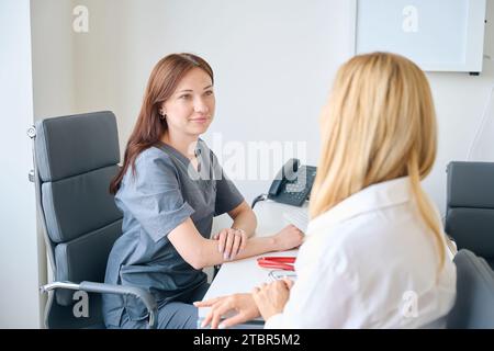 Qualifizierte Ärztin, die Erwachsene Patientin in ihrer Praxis empfängt Stockfoto