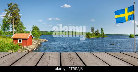 Rot auf einem See in Schweden mit schwedischer Nationalflagge Stockfoto