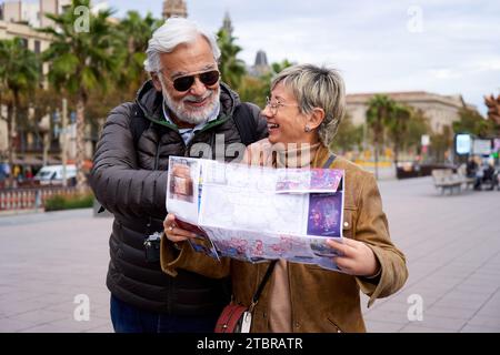 Glückliches Seniorenpaar, das Tourismus macht und sich durch eine Karte in der Stadt führt. Stockfoto
