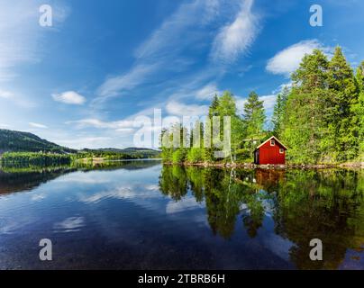 Rotes Haus an einem See in Skandinavien Stockfoto