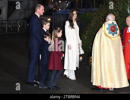 (Von links nach rechts) Prinz von Wales, Prinz George, Prinz Louis, Prinzessin Charlotte und Prinzessin von Wales, begrüßt von dem Dekan von Westminster, David Hoyle, während der Ankunft zu den Royal Carols - zusammen bei der Weihnachtsfeier in der Westminster Abbey in London. Bilddatum: Freitag, 8. Dezember 2023. Stockfoto