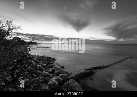 Sonnenaufgang am Strand Hovmarken auf der dänischen Insel Mön in der Ostsee, Steine am Strand, Mole, groyne, Mön, Dänemark Stockfoto