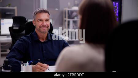 Zwei Personen, die sich während eines Gesprächsgesprächs in einem Büro unterhalten Stockfoto