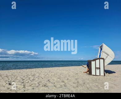 Weißer Liegestuhl steht im Sonnenlicht auf hellem Sand, Sommertag in Prerow an der Ostsee, Halbinsel Fischland-Darß-Zingst, Mecklenburg-Vorpommern, Deutschland Stockfoto