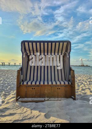 Deutschland, Mecklenburg-Vorpommern, Halbinsel Fischland-Darß-Zingst, Ferienort Prerow, abendliche Atmosphäre am Sandstrand, breite Liege, Ruheplatz, im Hintergrund die Betonsäulen des neuen Piers Stockfoto