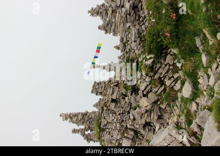 Bergmandl mit tibetischen Gebetsfahnen in dicht geweckt auf dem Weg zum Gipfel des Schafreuters (2,102 m) im Karwendelgebirge, Lenggries, Tölzer La Stockfoto