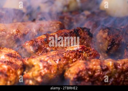 Traditionelle rumänischen Fleischbällchen "mici" auf dem Grill. Schmackhafte Fleischbällchen auf dem Grill, Schweinefleisch auf Holzkohlengrill Stockfoto